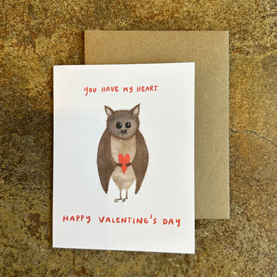 Valentine's Day card with a bat illustration and text on a textured surface